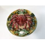 A continental dish with relief moulded and painted decoration incorporating a large crab, shells,