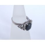 An 18ct white gold sapphire and diamond dress ring. Central 10mm x 7mm dark blue sapphire in 4 prong