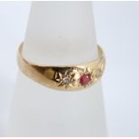 An 18ct gold ruby and diamond ring, small central star set ruby accented with illusion set diamonds.