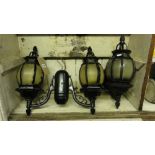 A pair of exterior porch wall lights with cast metal frames and shaped brackets together with