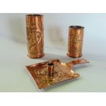 Three pieces of Arts & Crafts style embossed copper in the manner Newlyn comprising two cylinder