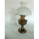 A brass oil lamp with opaline glass shade.