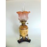 A late 19th century Aesthetic movement ceramic oil lamp and decorated glass shade, the ovoid