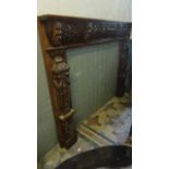 A good quality hardwood chimney piece/fire surround with scrolling carved lions mask and further