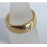 An 18ct gold wedding band set with single square cut diamond 17g. Ring size V