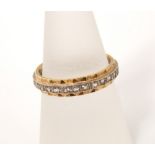 An 18ct white and yellow gold diamond full eternity ring set throughout with a line of single cut