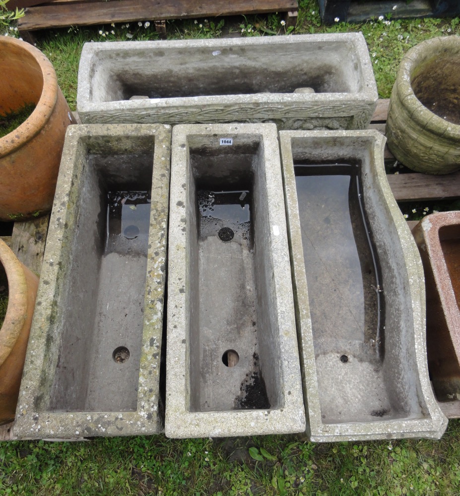 Four various weathered reconstituted garden planters, all with decorative panels, 70 cm long