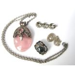 A Scottish sterling silver pendant set with large free cut rose quartz on an ornate mount, centrally