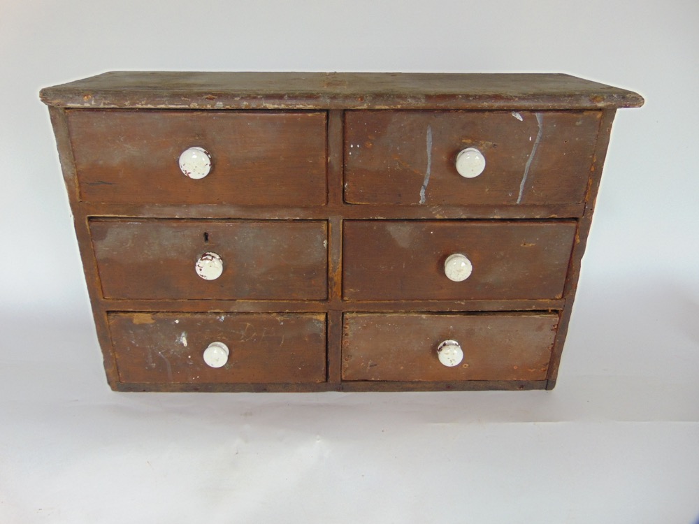 Victorian stained pine bank of six specimen drawers, each with ceramic handles, 33cm high by 51cm