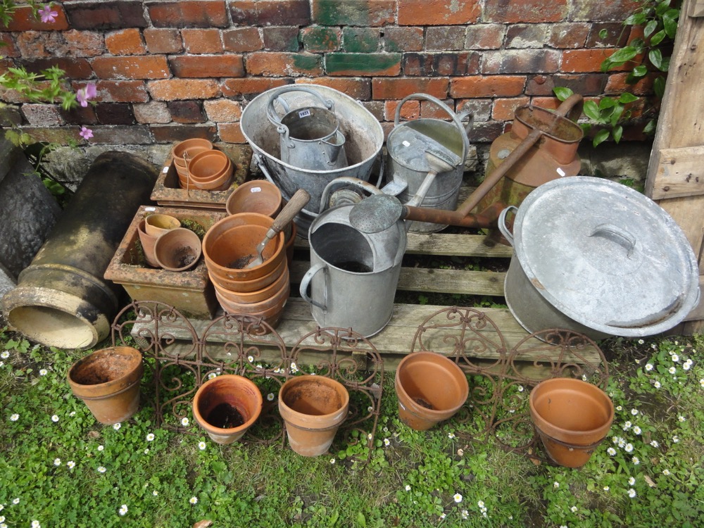 A weathered composition stone garden urn with circular waisted bowl raised on a square pedestal with