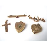 Three 9k gold items to include a cross pendant, a ruby set bar brooch, a pin brooch with horseshoe