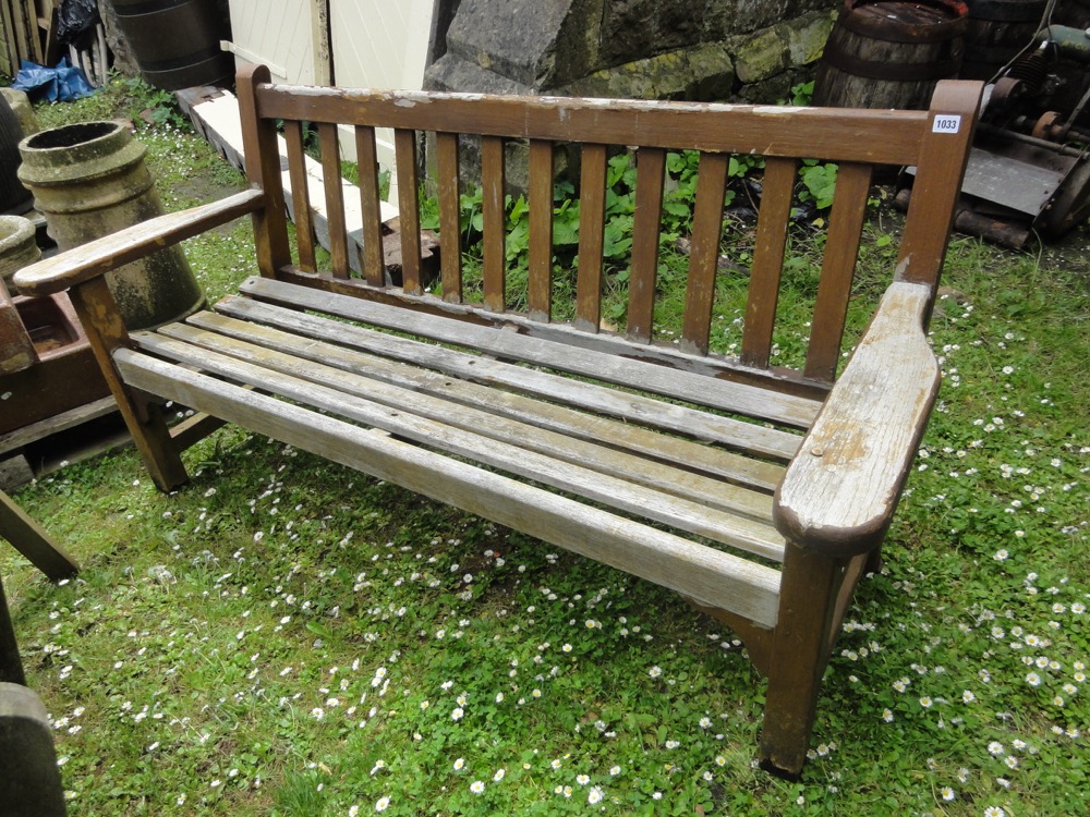 A weathered teak three seat garden bench with slatted seat and back, 5ft long approx.