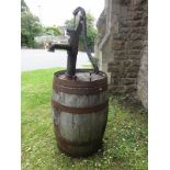 A coopered oak barrel supporting a water pump.