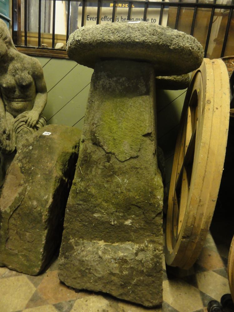 A pair of substantial weathered stone saddle stones and caps, 95 cm high approx.