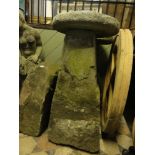 A pair of substantial weathered stone saddle stones and caps, 95 cm high approx.