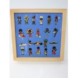 A framed collection of 21 Roberstons Golly enamel badges