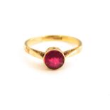 A ladies 18k gold and synthetic ruby ring, central round cut ruby in openwork colette set rub over