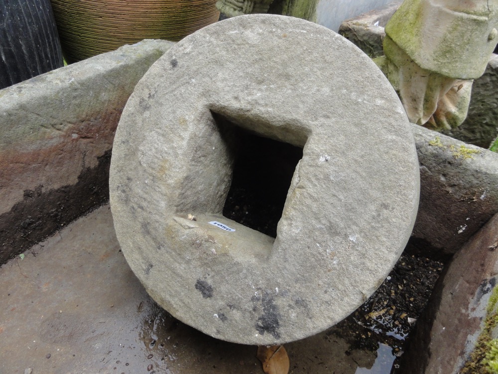 A circular mill or sharpening stone, 35 cm diameter with central square cut centre.