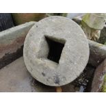 A circular mill or sharpening stone, 35 cm diameter with central square cut centre.