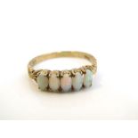 A 9ct gold five stone opal ring with engraved and decorated shoulders, ring size R, 2.3 g