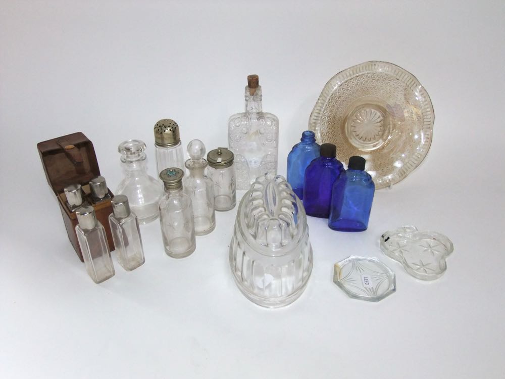 A collection of glassware to include glass jelly mould, three piece star cut glass cruet, three blue