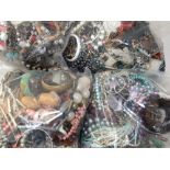 Four large sealed bags of costume jewellery.