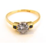 A 9k gold and white metal ladies diamond ring with small square cut sapphire shoulders, central