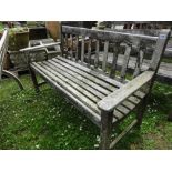 A weathered Britannic Teak two seat garden bench with slatted seat and back (AF).