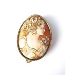 A large oval 19th century shell cameo brooch, depicting a classical female in an unmarked yellow