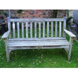 A weathered teak two to three seat garden bench with slatted seat and back by Lister, Dursley, Glos,