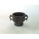 An archaic looking Chinese bronze sensor embossed with various medallions, 9 cm high approx.