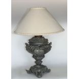 A cast metal baluster table lamp in the form of a companion urn embossed with cherubs and foliage.