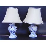 A pair of blue and white pottery baluster table lamps together with a collection of lamp shades