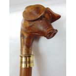 A walking stick with carved pigs head knop.