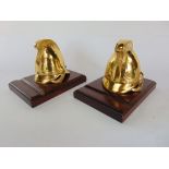 Pair of cast gilt metal standish inkwells in the form of military helmets, upon wooden plinth