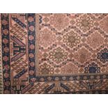 Persian style floor rug decorated with geometric blue and brown medallions upon a peach ground,