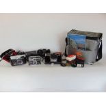 A travel bag fitted with a collection of vintage cameras and equipment to include lenses, etc.