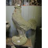 A weathered cast composition stone garden ornament in the form of a cockerel, 60 cm high approx (