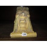 A 19th century corbel in the form of a laughing bearded man with further acanthus and scrolled