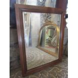 An Edwardian mahogany overmantle mirror with rectangular bevelled edge plate flanked by moulded arch