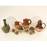 A collection of Doulton and other salt glazed stone wares including a jug with offset handle and