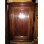 Georgian oak country made hanging corner cupboard enclosed by a single panelled door with shaped