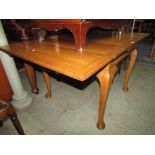 An oak draw leaf dining table on shaped supports together with four oak lathe back dining chairs.