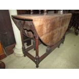 A Georgian oak gate leg table on eight gun barrel shaped support. 115cm in length.