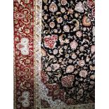 A good quality modern Persian carpet profusely decorated with scrolled foliage upon a black