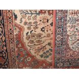 Modern Persian style floor rug decorated with various blue medallions upon an orange ground;