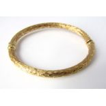 An 18ct gold hinged bangle with textured finish, 13g