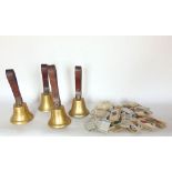 Four leather handled ringing bells together with a collection of cigarette cards and coinage