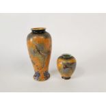 An orange ground Carlton ware vase with painted and gilded exotic bird, butterfly, flowering tree