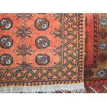 Two very similar Bokara prayer mats/floor rugs decorated with geometric medallions upon an orange